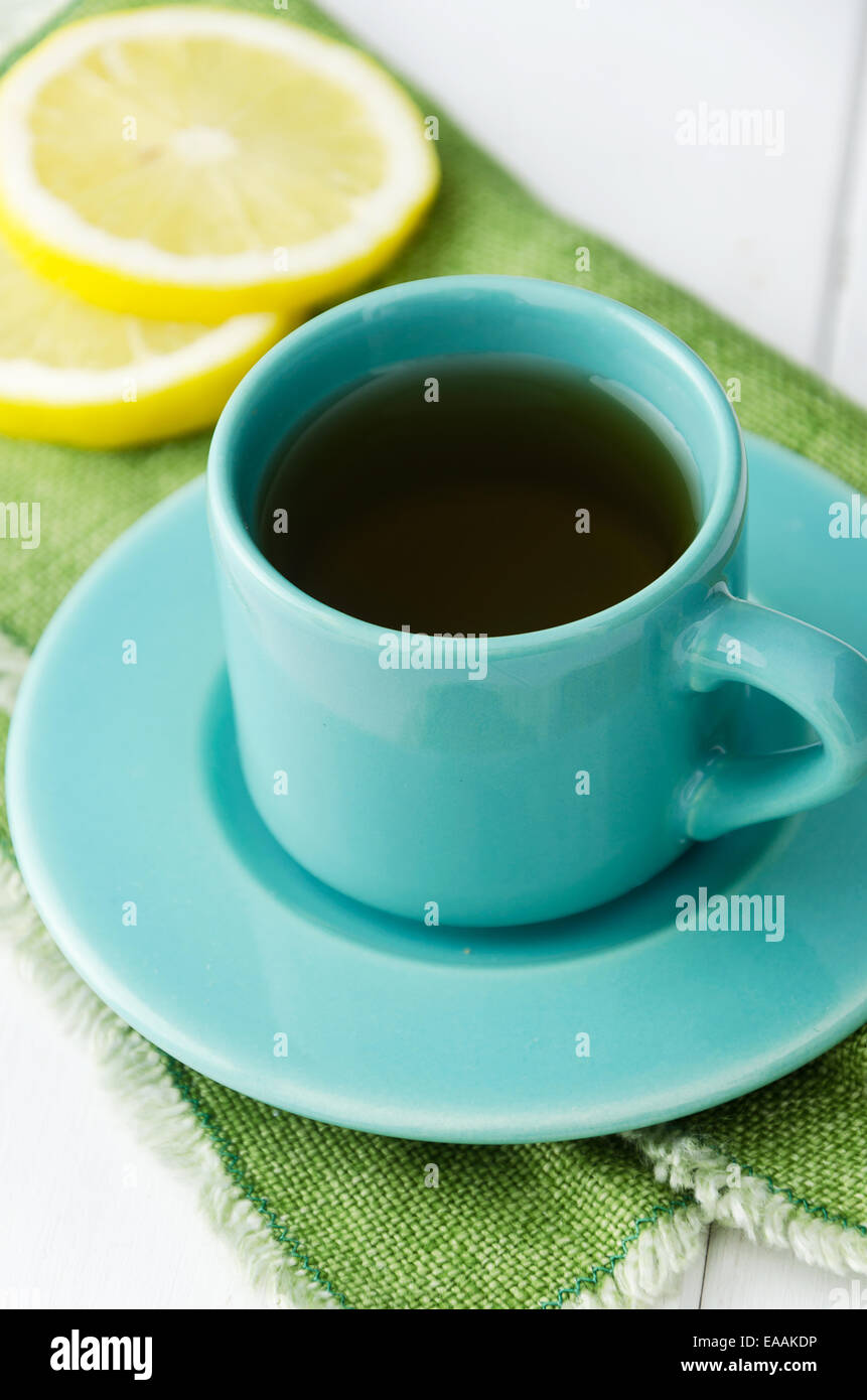 Close up de thé à la menthe en bleu tasse avec du citron sur toile verte Banque D'Images