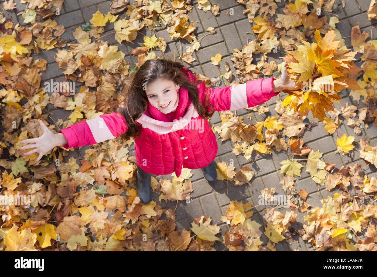 Girl with hand up in autumn park Banque D'Images