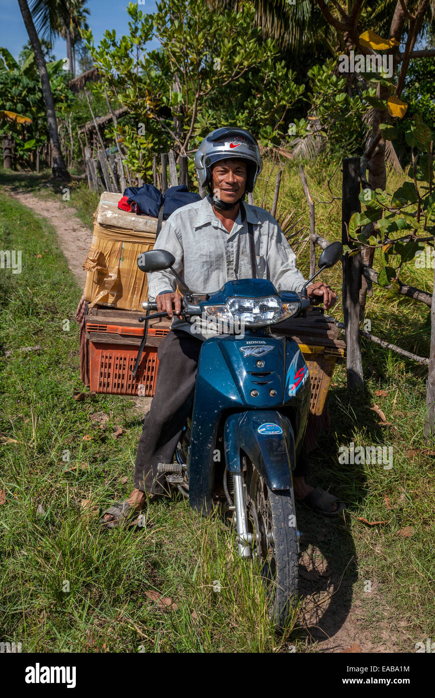 Le Cambodge. Transport de marchandises à l'homme sur sa moto. Banque D'Images