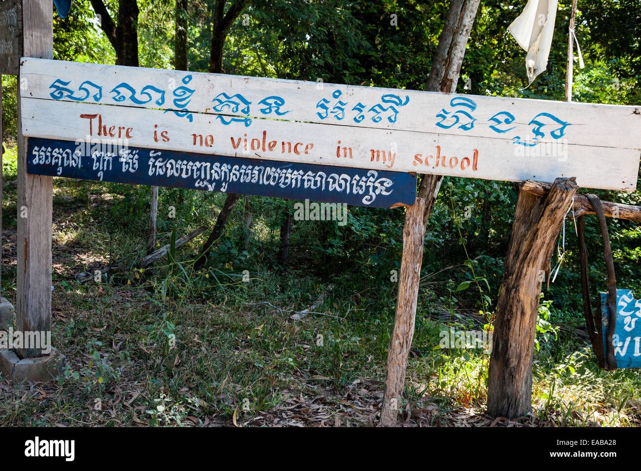 Le Cambodge. "Pas de violence dans mon école' signe en entrée de l'école. Signer en Khmer et Alphabets romain. Banque D'Images