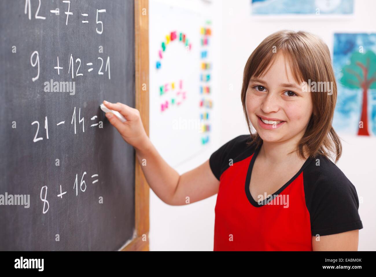 Heureux l'écriture d'écolière élémentaire solution équation on chalkboard Banque D'Images