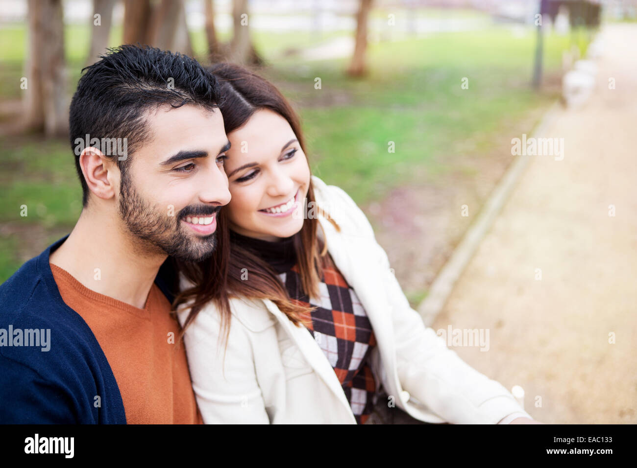 Jeune couple sur un banc dans le parc Banque D'Images