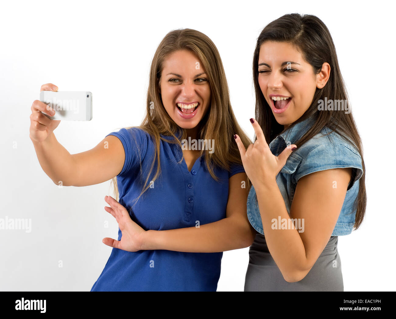Deux jolies jeunes filles qui posent comme des stars du rock Selfies tout en tenant Banque D'Images