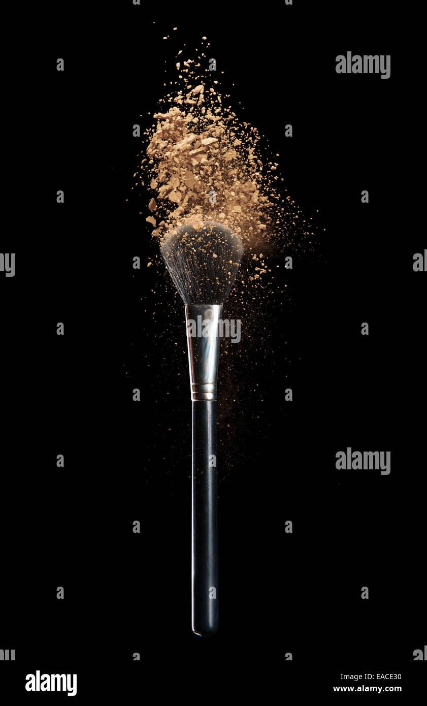 Make-up isolés à l'aide d'un pinceau poudre sur fond noir Banque D'Images