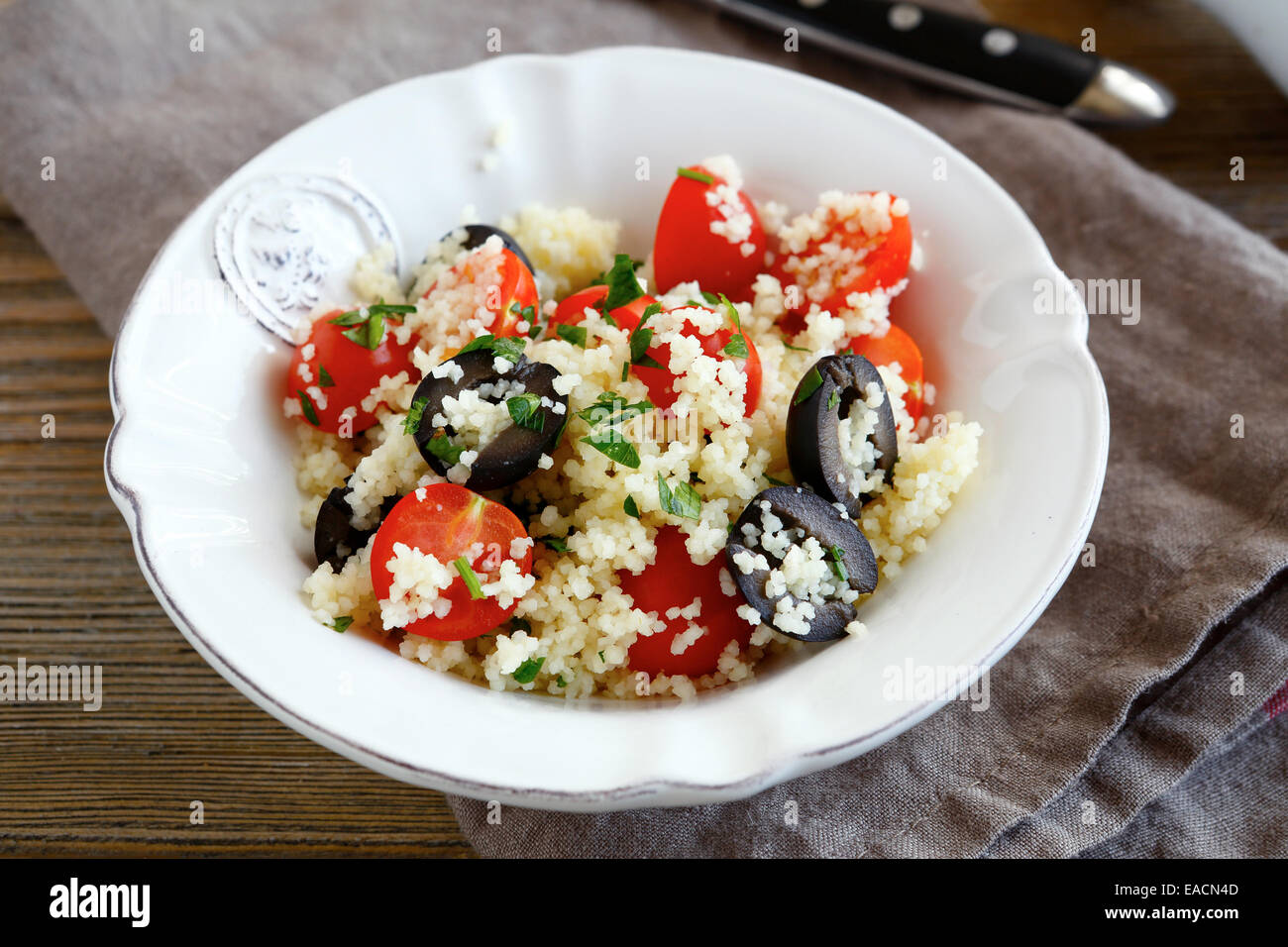 Délicieuse salade couscous aux légumes et olives sur une assiette, Close up Banque D'Images