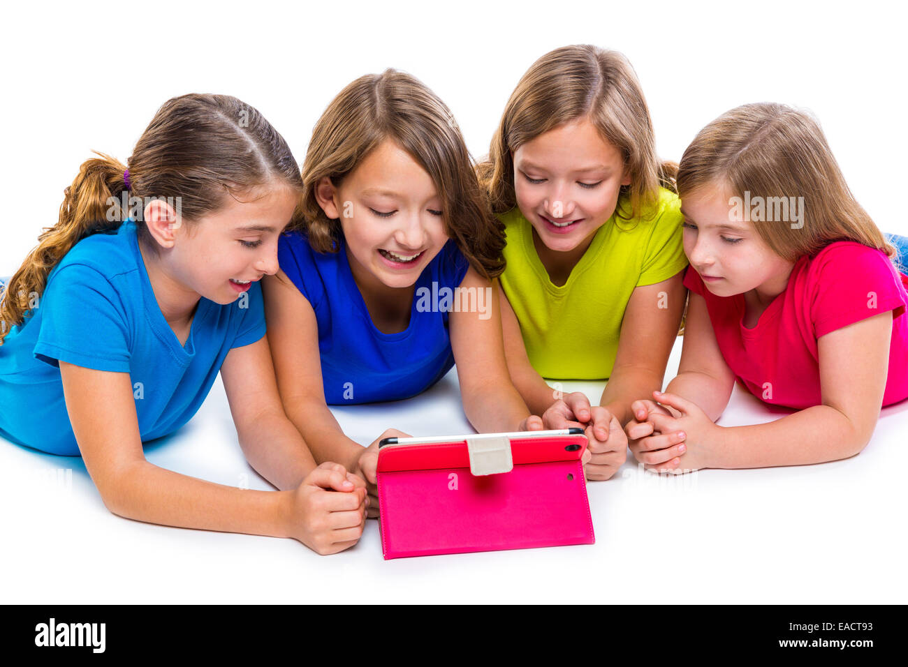 Sœurs cousins kid filles avec tech tablette pc jouer heureux couché sur fond blanc Banque D'Images