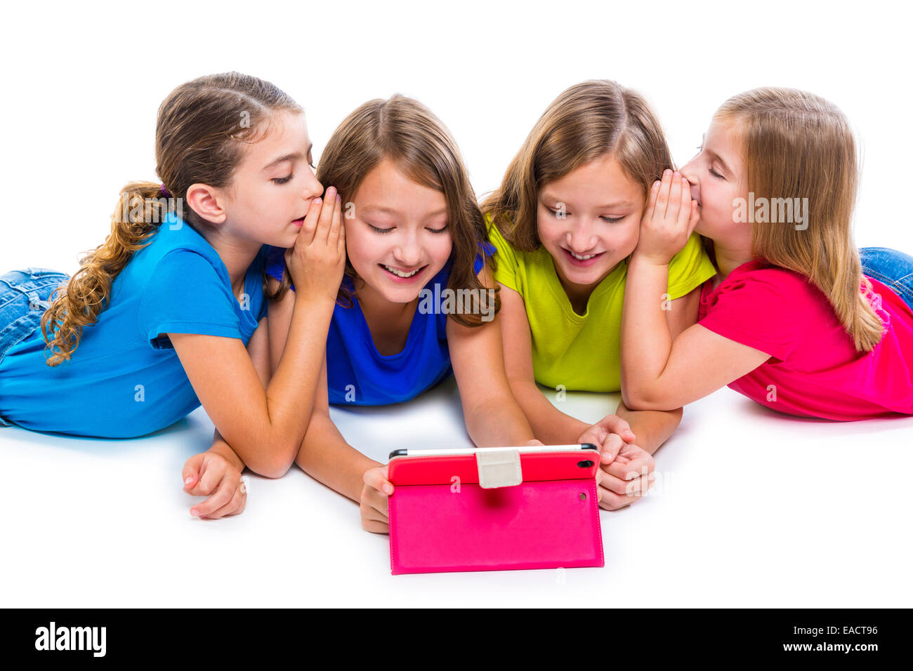 Sœurs cousins kid filles avec tech tablette pc jouer heureux couché sur fond blanc Banque D'Images