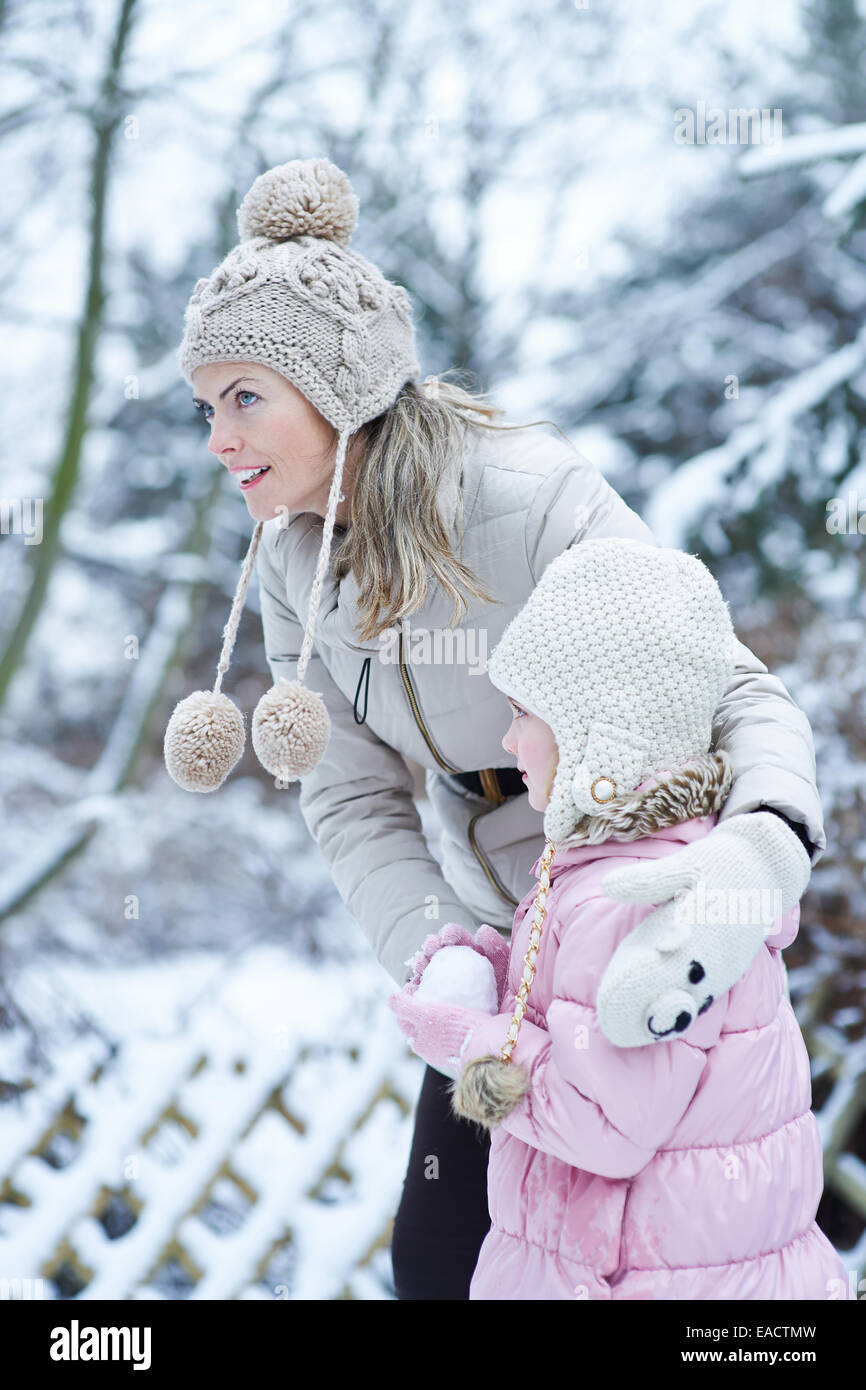 La mère et l'enfant formant un ensemble de boules de neige en hiver Banque D'Images