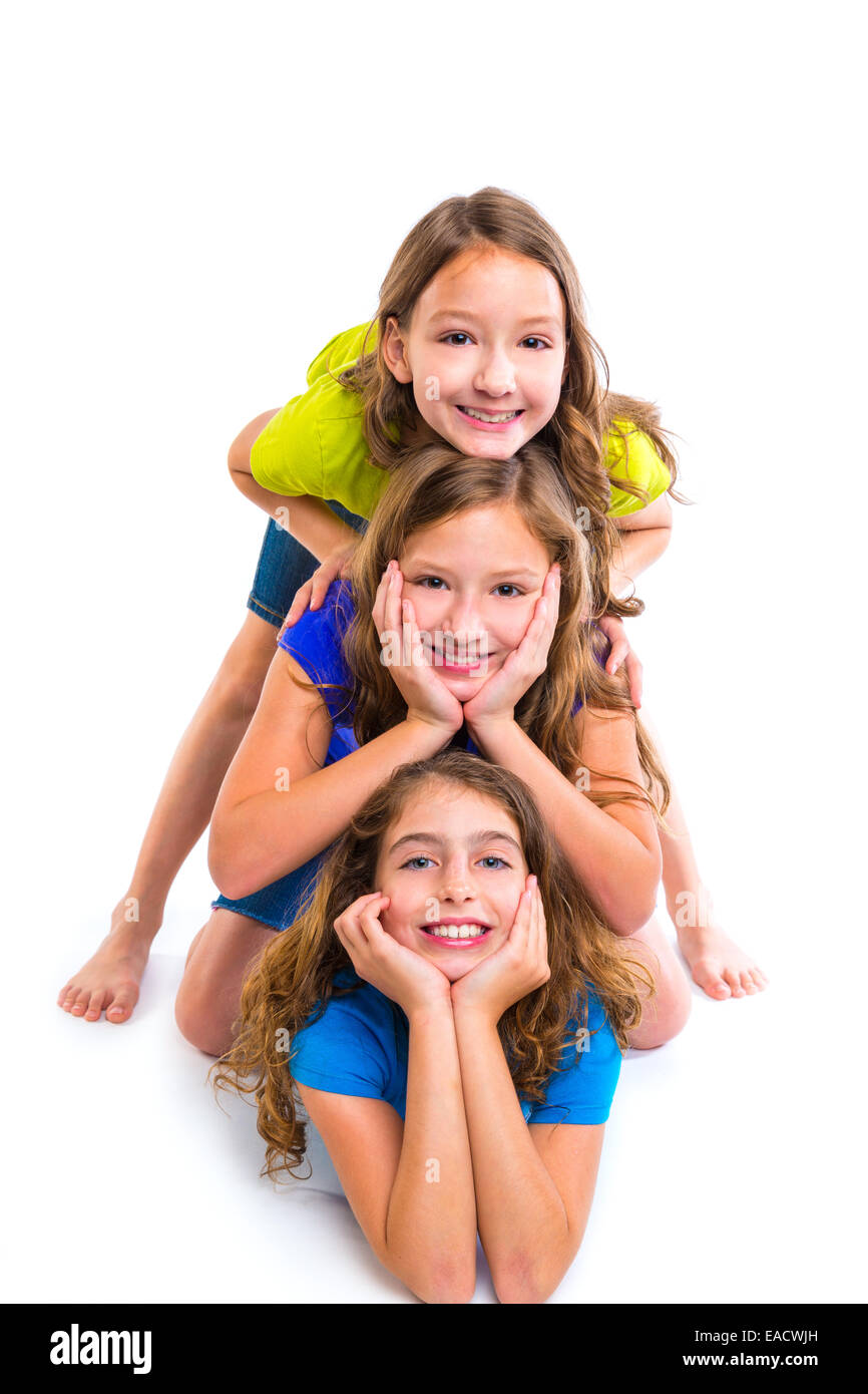 Trois filles enfants heureux amis empilés dans une rangée portrait sur fond blanc Banque D'Images