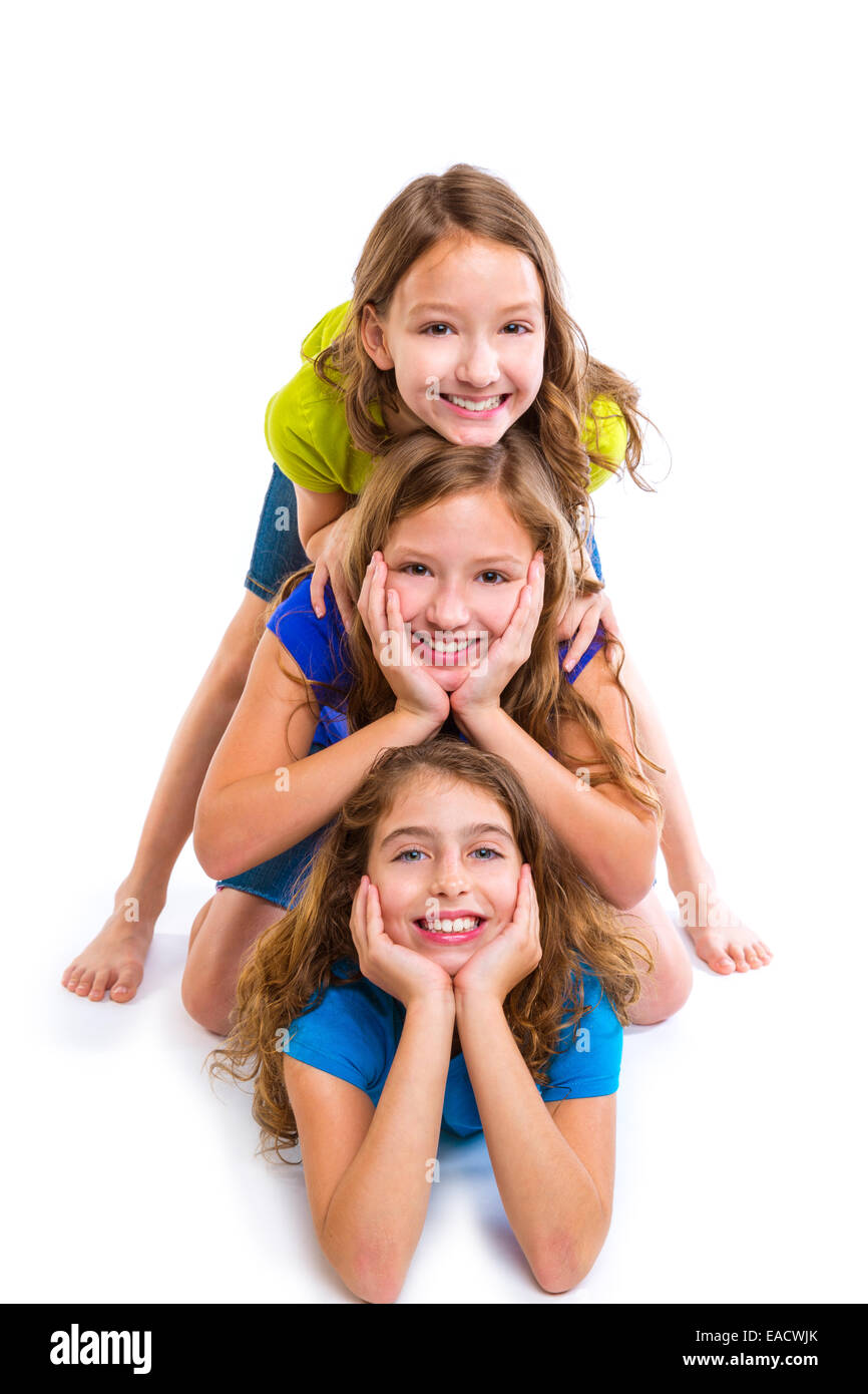 Trois filles enfants heureux amis empilés dans une rangée portrait sur fond blanc Banque D'Images