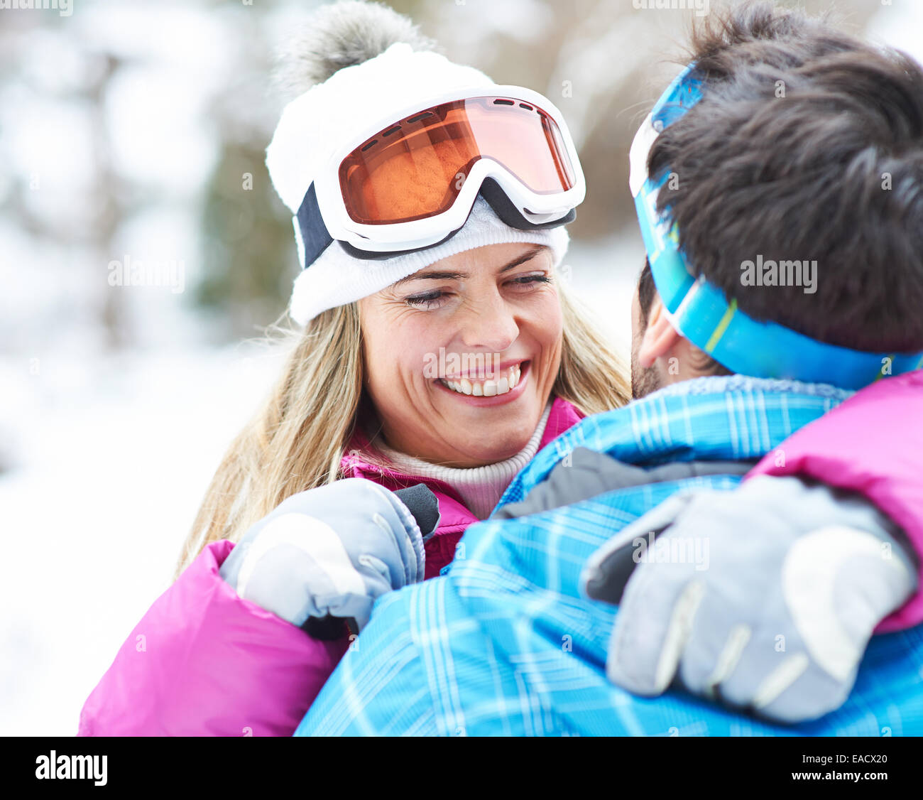 Happy smiling couple ensemble dans une maison de vacances de ski l'hiver avec googles Banque D'Images