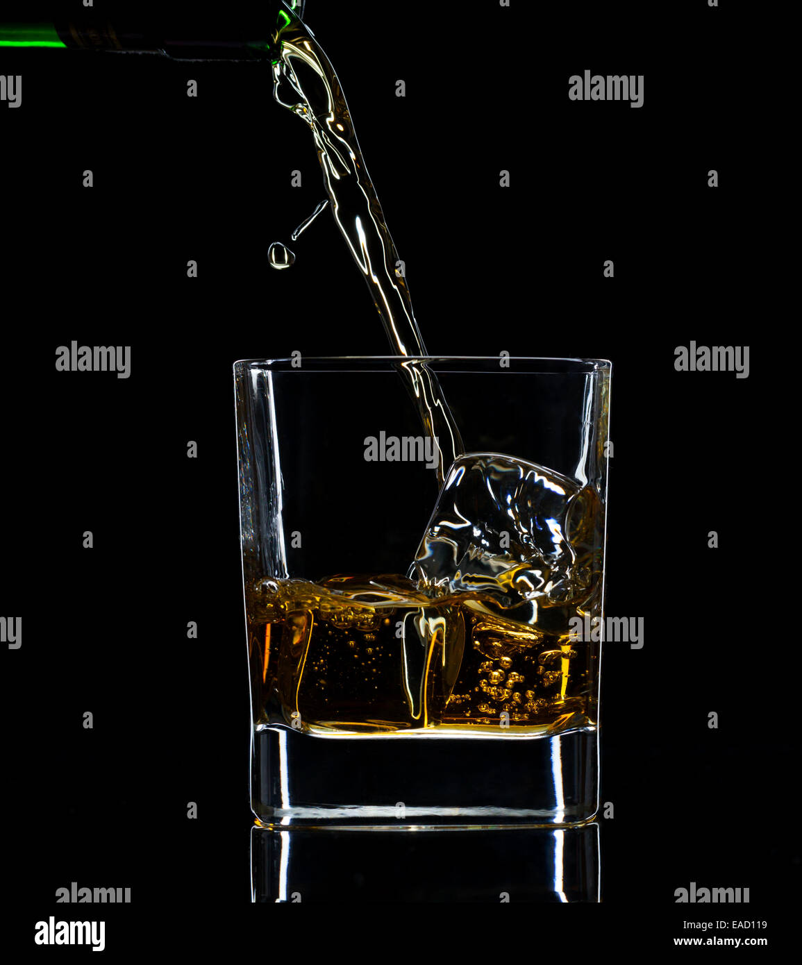 Verser dans un verre à whisky, isolé sur fond noir Banque D'Images
