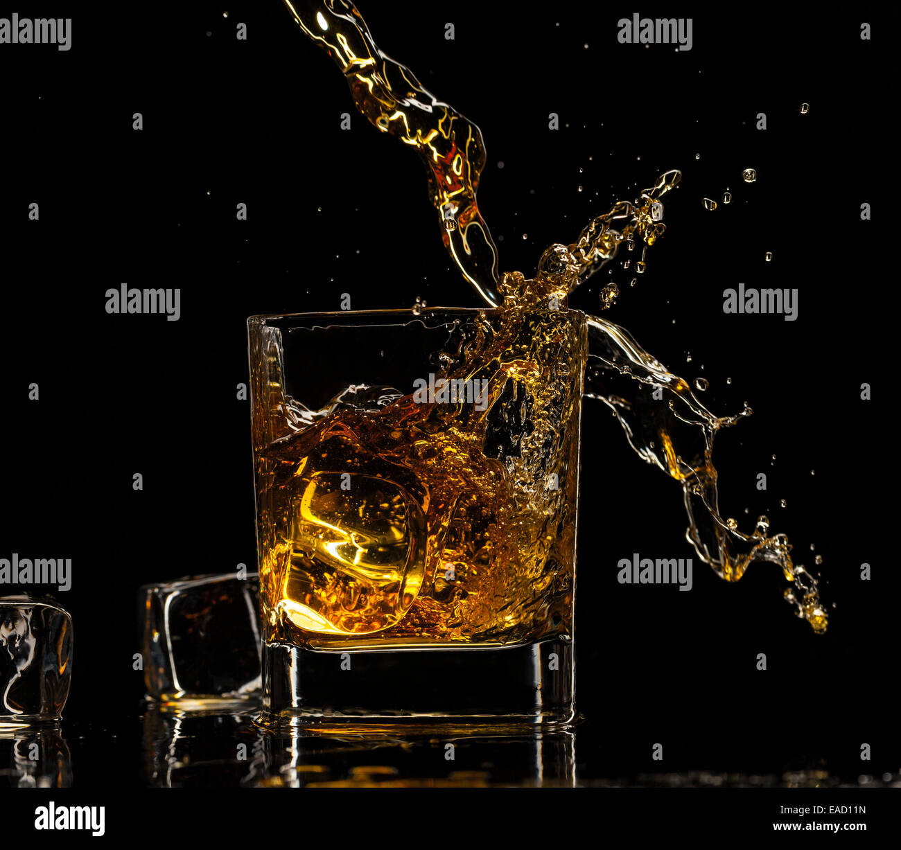 Verser dans un verre à whisky, isolé sur fond noir Banque D'Images