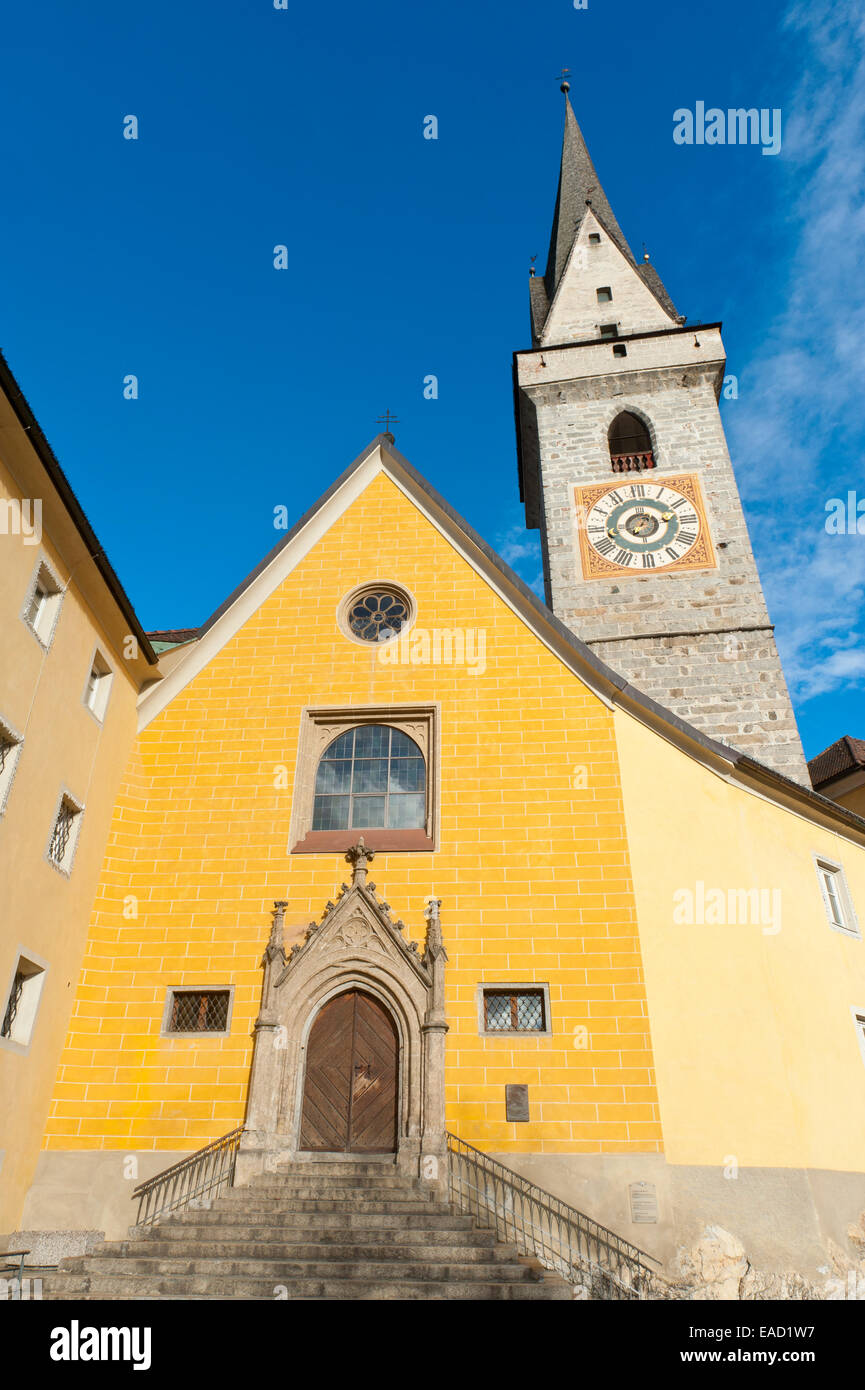 L'église peinte en jaune avec un clocher, l'Église des Ursulines, rue, centre historique de la ville de Brunico, l'Alto Adige, Trentino-Alto Adige Banque D'Images