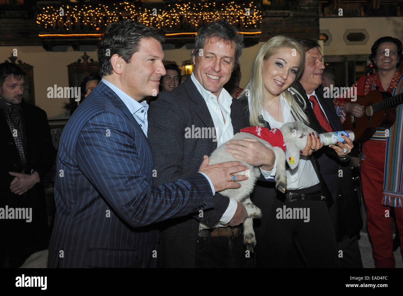 Henndorf près de Salzbourg, Autriche. 11 novembre, 2014. L'acteur britannique Hugh Grant est titulaire d'un agneau sur Novembre 11, 2014 à l'ouverture du marché de Noël à Aiderbichl Estate à Henndorf près de Salzbourg, Autriche. À gauche Kathrin Glock, épouse de l'armurier Gaston Glock et à droite l'acteur Francis Fulton Smith. Dpa : Crédit photo alliance/Alamy Live News Banque D'Images