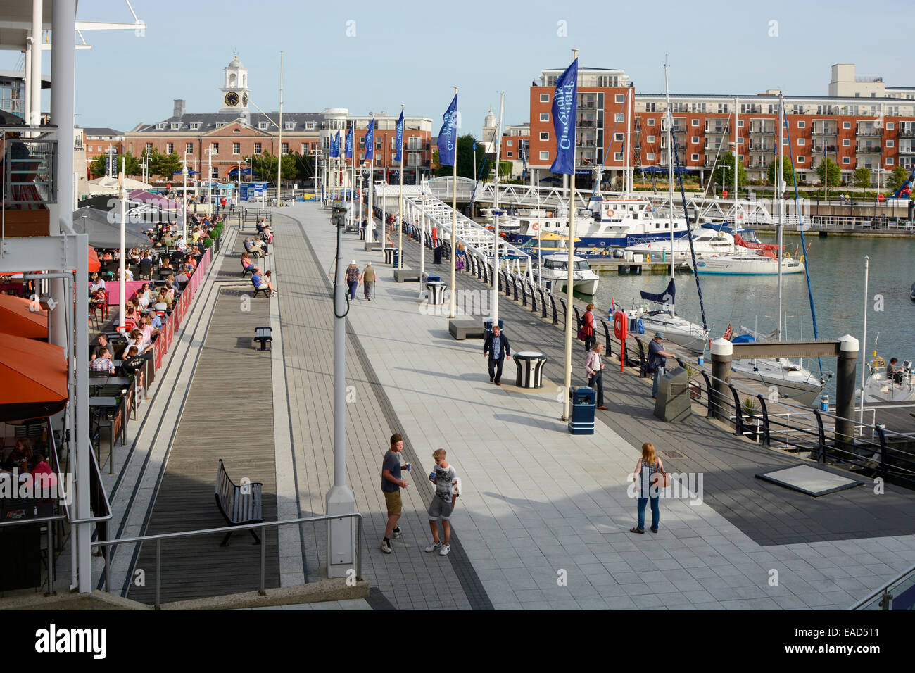 Les gens assis à des tables à l'extérieur de la zone de restaurant au centre commercial GUNWHARF QUAYS. Portsmouth. Le Hampshire. L'Angleterre. Avec apar Banque D'Images