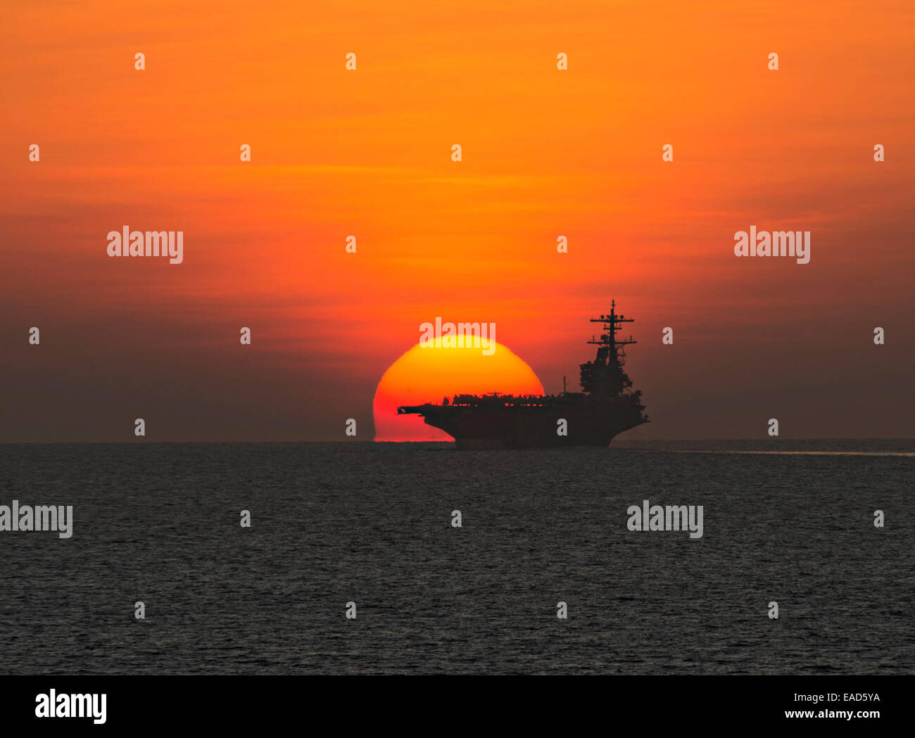 L'US Navy porte-avions USS George H. W. Bush est découpé par le coucher de soleil qu'il transite le golfe d'Aden, le 23 octobre 2014. Le George H. W. Groupe aéronaval du Bush est de retour au Naval Station Norfolk après production des opérations de grève en Iraq et en Syrie dans le cadre de la 5e Flotte des États-Unis. Banque D'Images