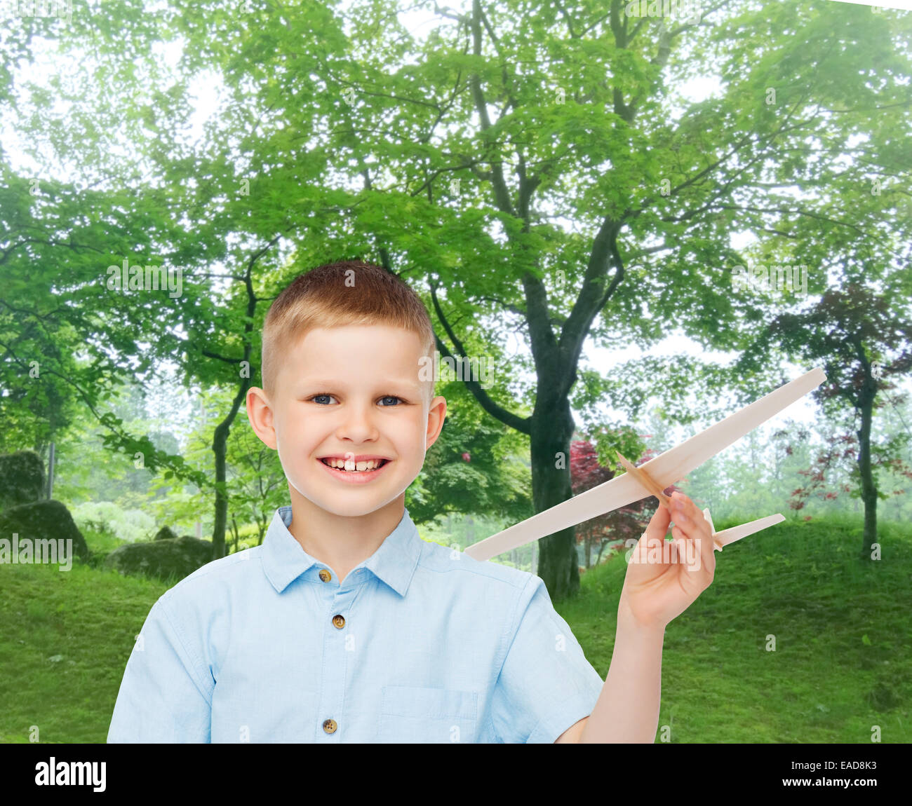 Smiling little boy holding un modèle d'avion en bois Banque D'Images