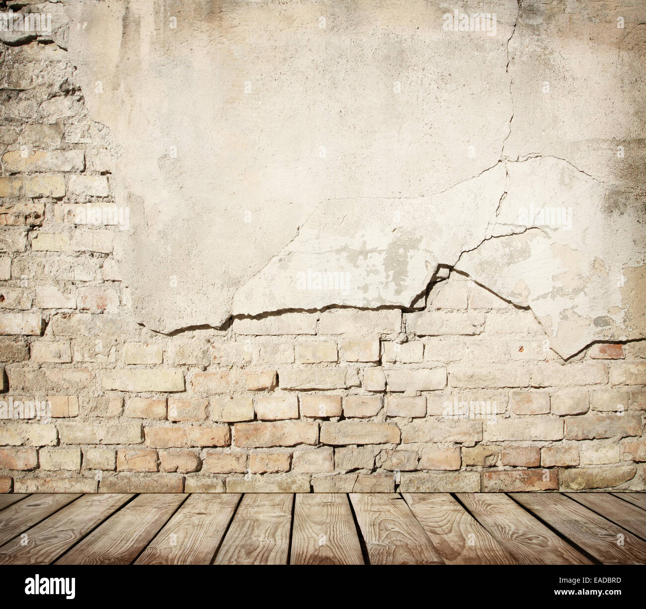 Mur de brique fissurée avec plancher en bois Banque D'Images