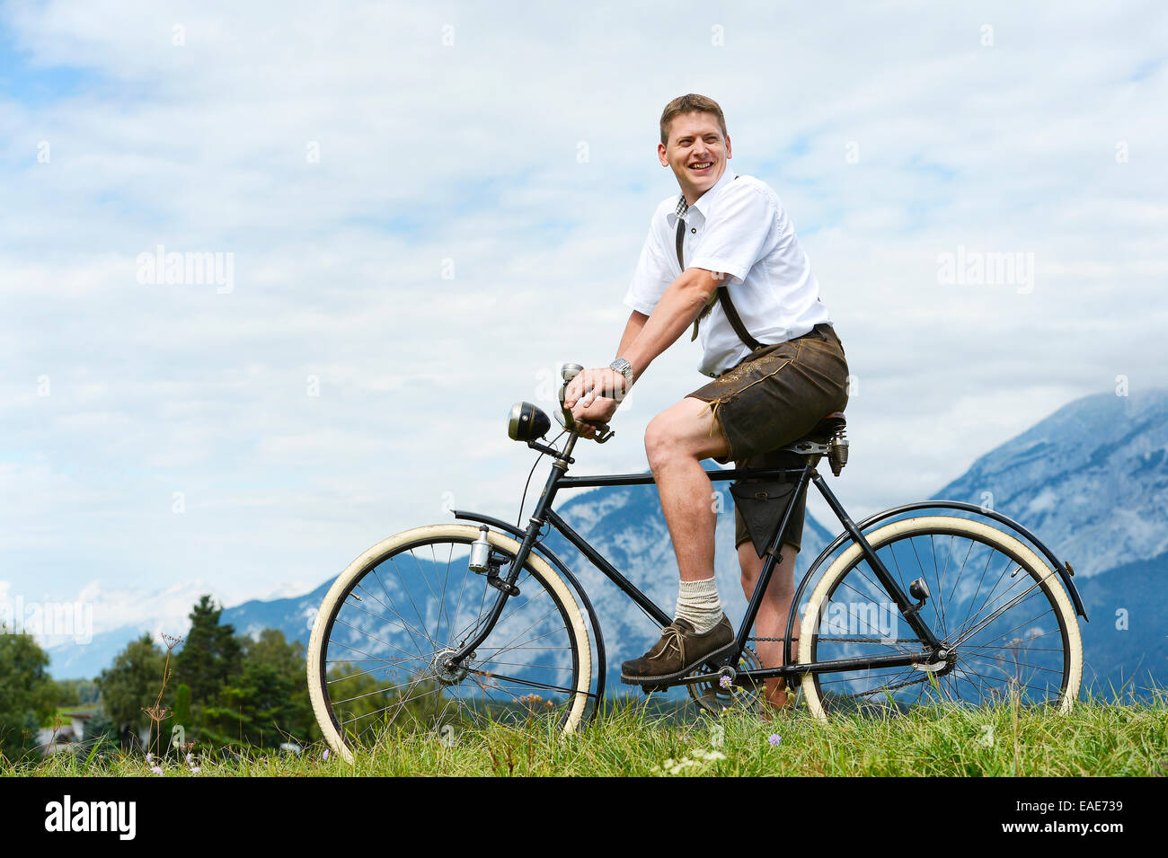 Homme portant un pantalon en cuir sur un vieux vélo, Innsbruck, Innsbruck, Tyrol, Autriche Banque D'Images