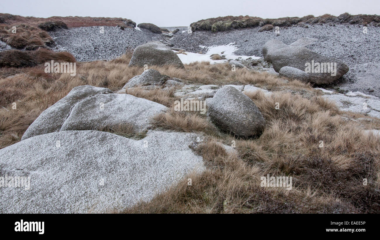 Les affleurements de roches avec des graminées lande couverte dans la première chute de neige sur Kinder scout dans le Peak District, Derbyshire. Banque D'Images