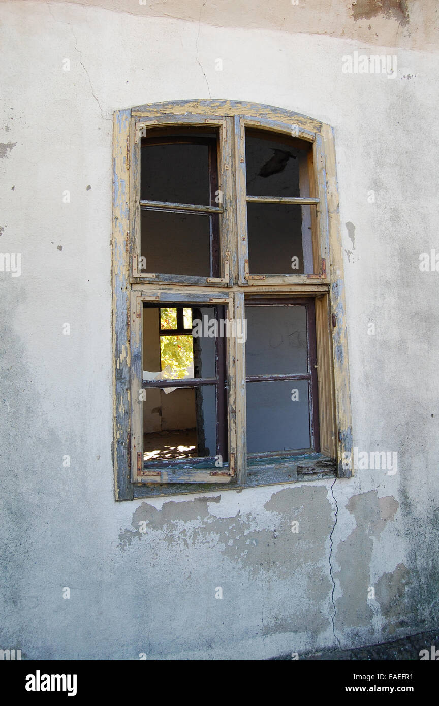 L'ancienne fenêtre à deux portes délabrées dans une ferme abandonnée. Par la fenêtre, vous pouvez voir l'intérieur de la chambre. Banque D'Images