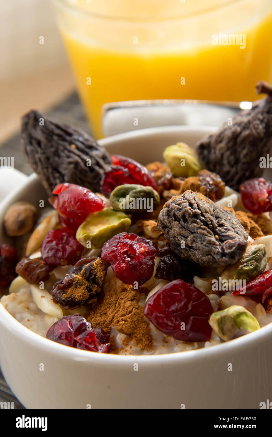 Petit déjeuner nutritif - jus d'orange et d'avoine avec des fruits secs et de noix garniture Banque D'Images