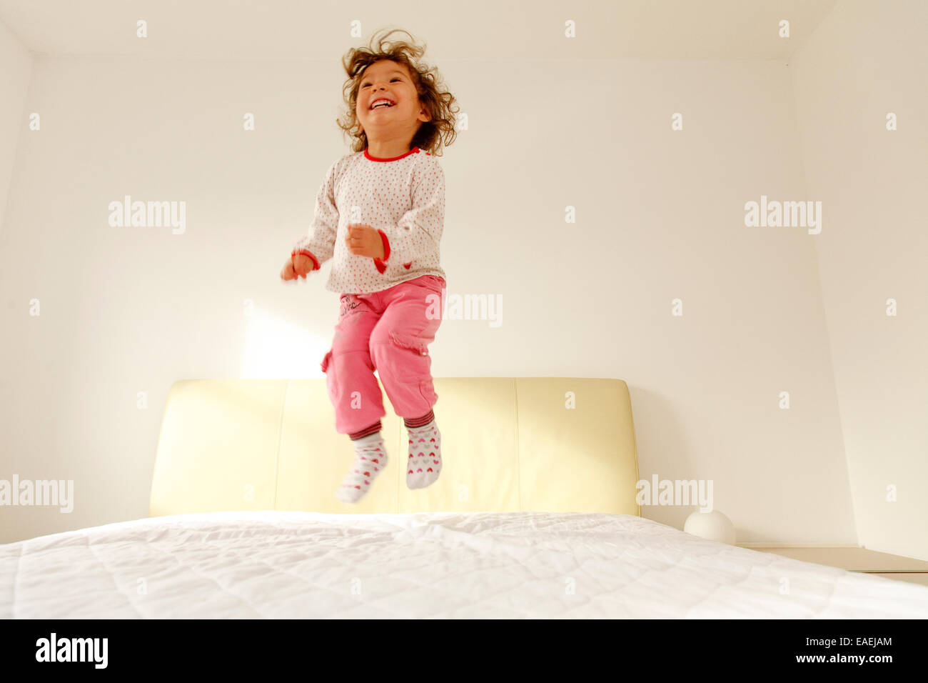 Un Enfant De Deux Ans Sauter Sur Un Lit Photo Stock Alamy