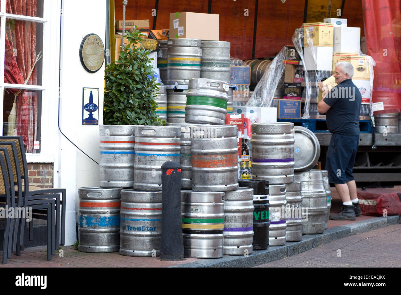 Homme décharger un camion qui transporte des fûts et des spiritueux pour un public house en Angleterre Banque D'Images