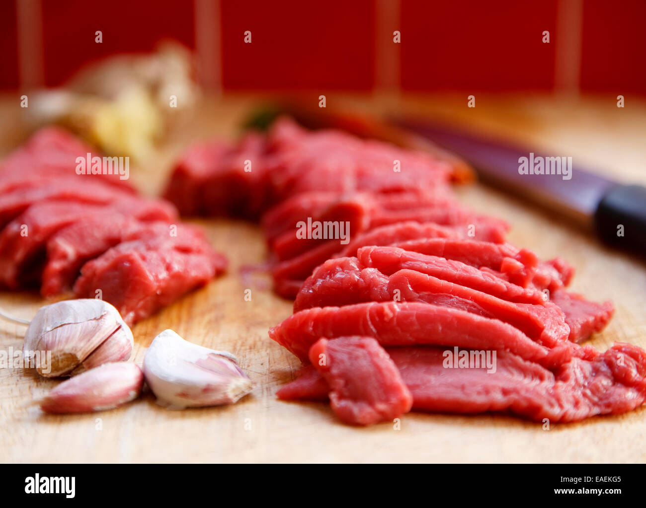 Fabricants de bandes de brutes rose frais pavé de rumsteak avec l'ail sur une planche à découper en bois, differential focus Banque D'Images