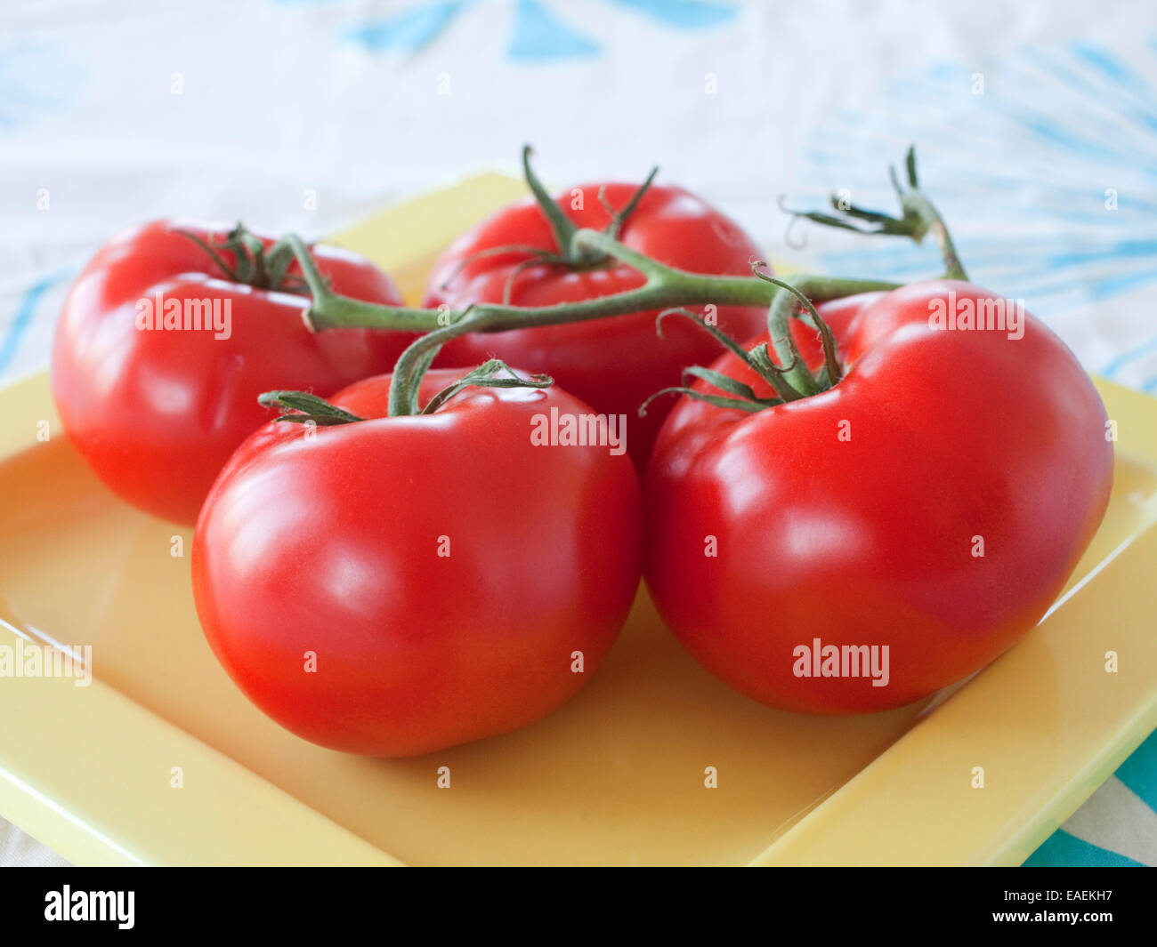 4 tomates mûres sur une plaque Banque D'Images