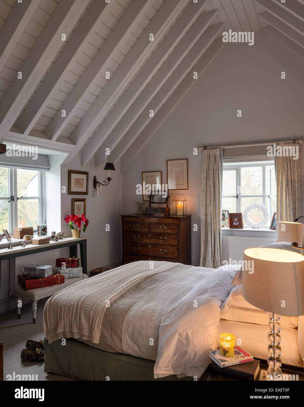 Pays se sentent chambre avec plafond à poutres apparentes, commode ancienne et verre lampe de chevet Banque D'Images