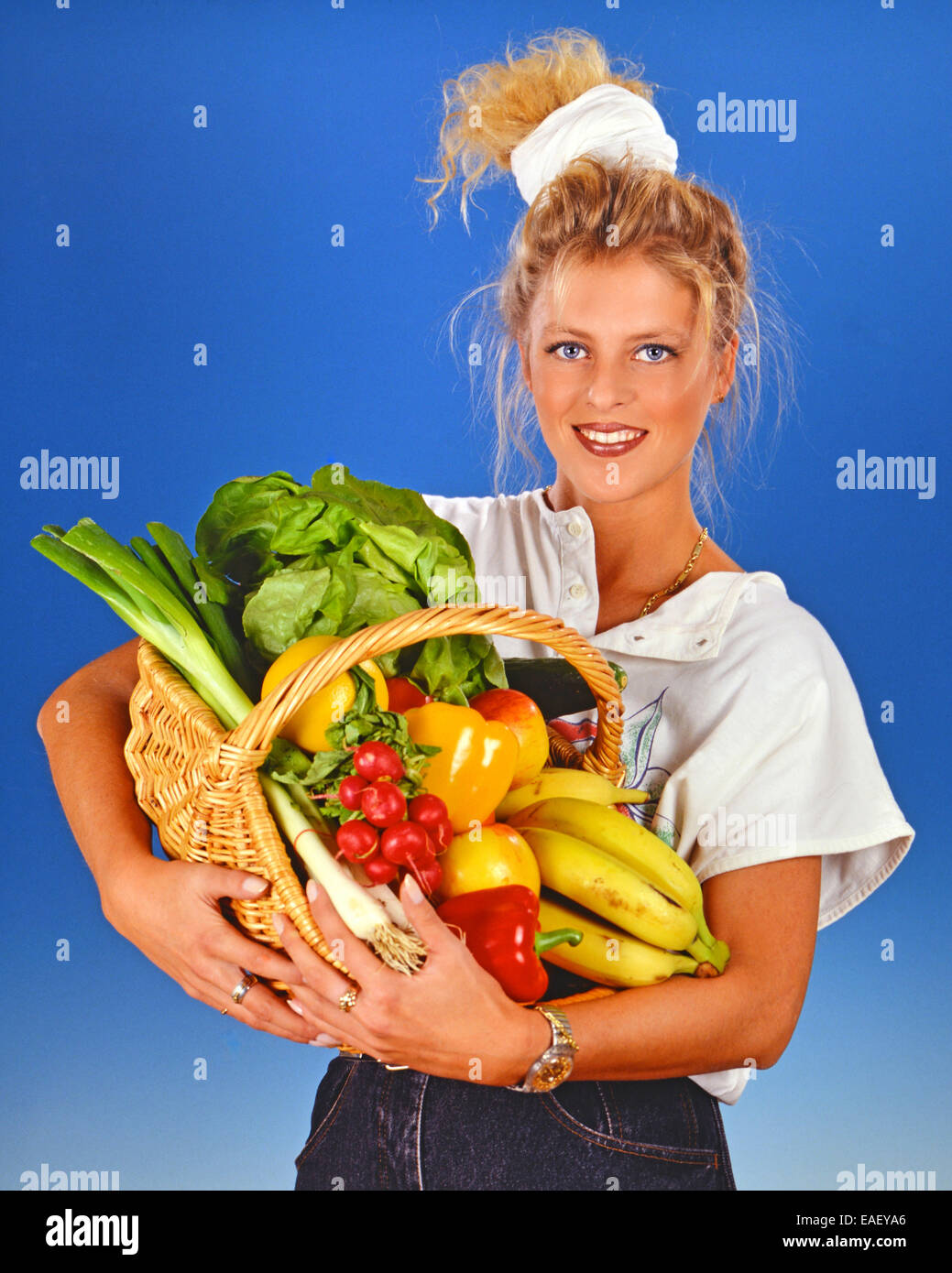 Femme blonde avec un panier plein de légumes Banque D'Images