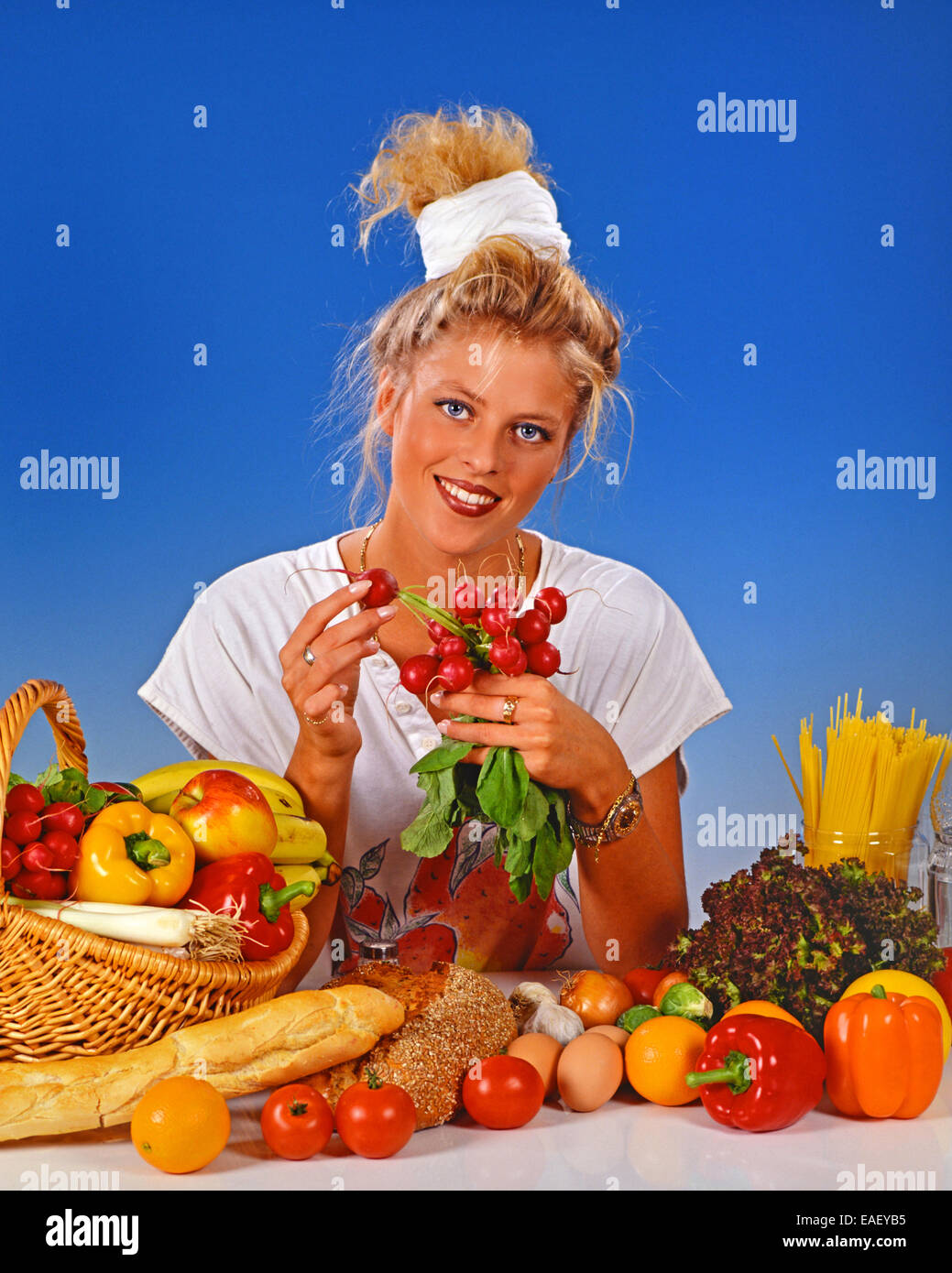 Femme blonde radis manger pour le petit déjeuner Banque D'Images