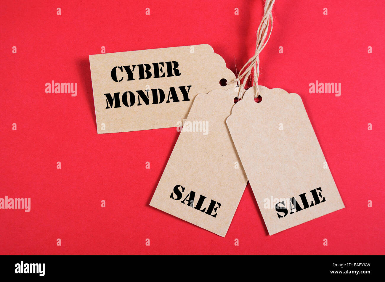 Vente Cyber Monday shopping message sur trois papier kraft brun shopping tags sur fond rouge. Banque D'Images