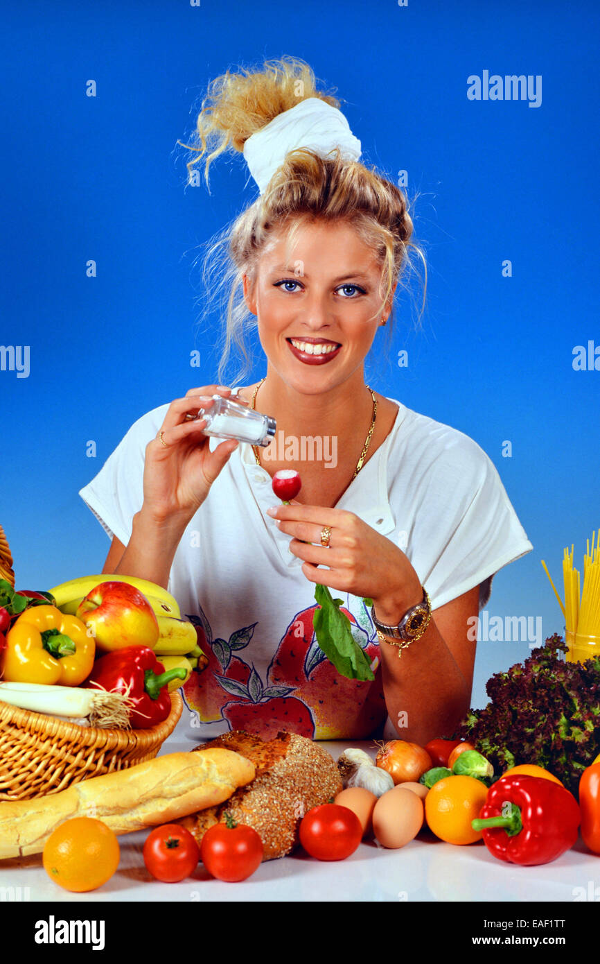 Femme blonde avec des radis manger pour le petit déjeuner Banque D'Images