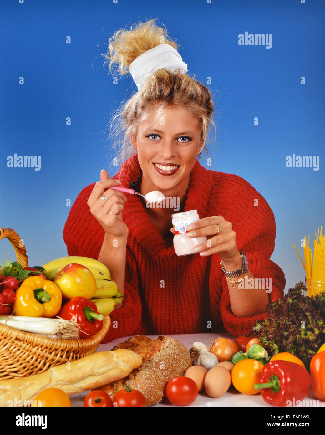 Femme blonde manger du yogourt pour le petit déjeuner Banque D'Images