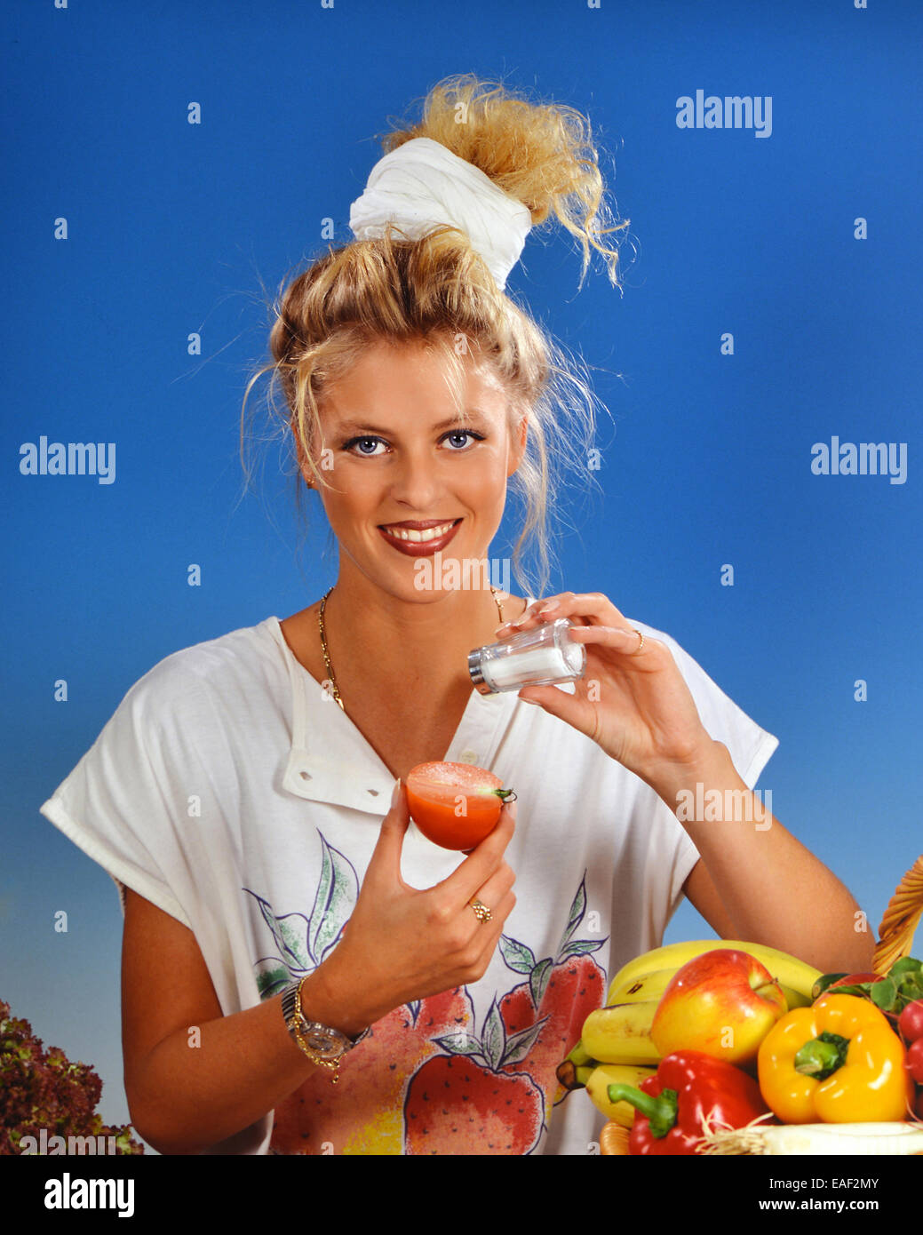 Femme blonde avec du sel tomate manger pour le petit déjeuner Banque D'Images