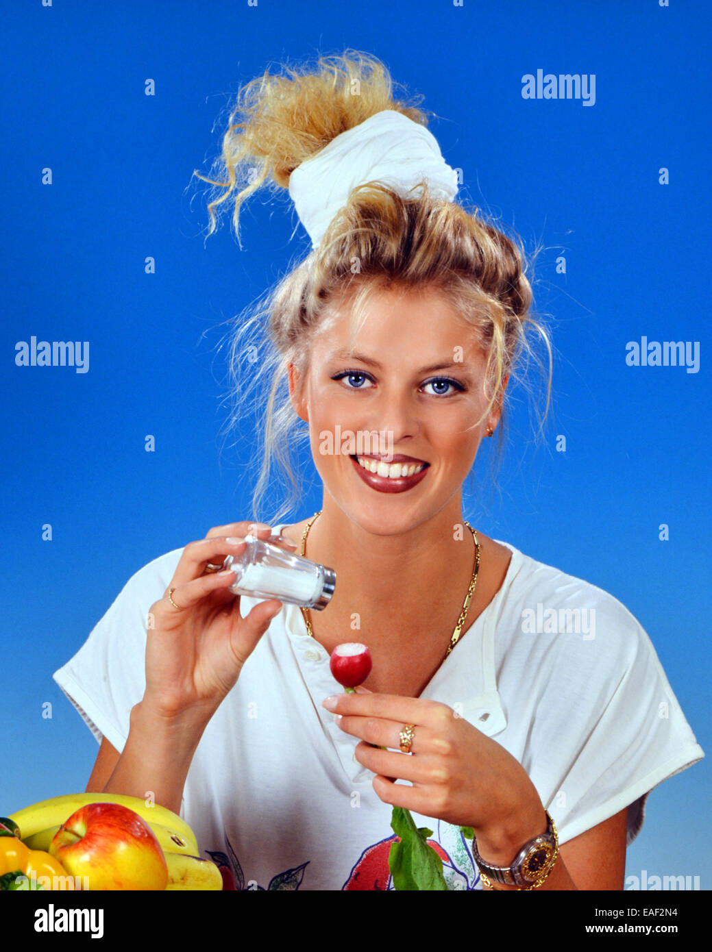 Femme blonde manger des radis avec du sel pour le petit déjeuner Banque D'Images