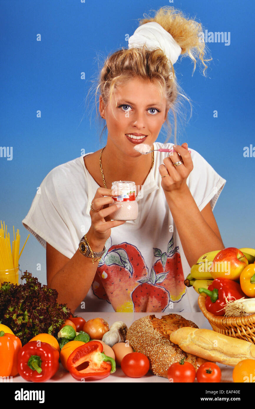 Femme blonde manger un yaourt Banque D'Images