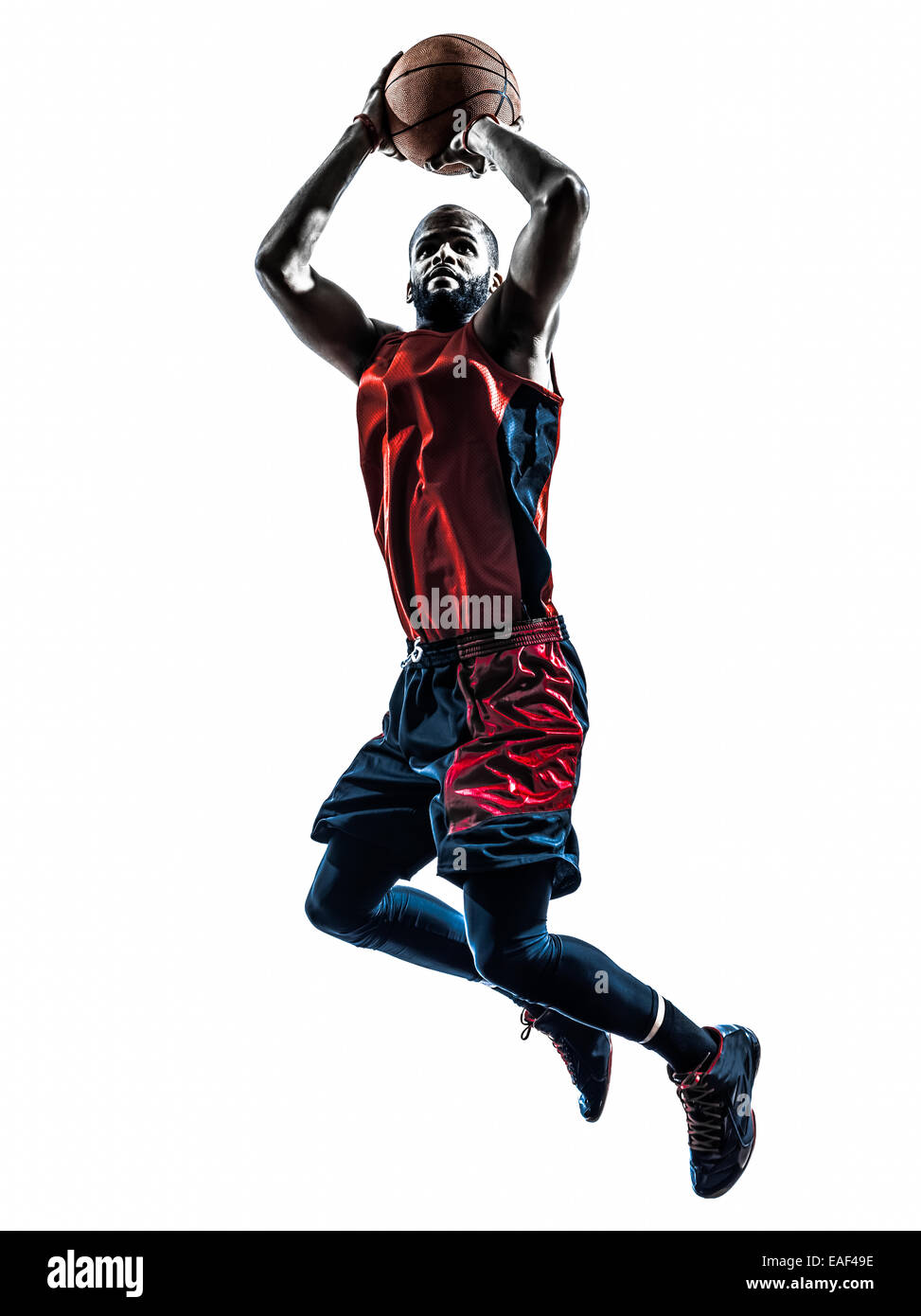 Un joueur de basket-ball homme africain en jetant de saut isolé silhouette fond blanc Banque D'Images