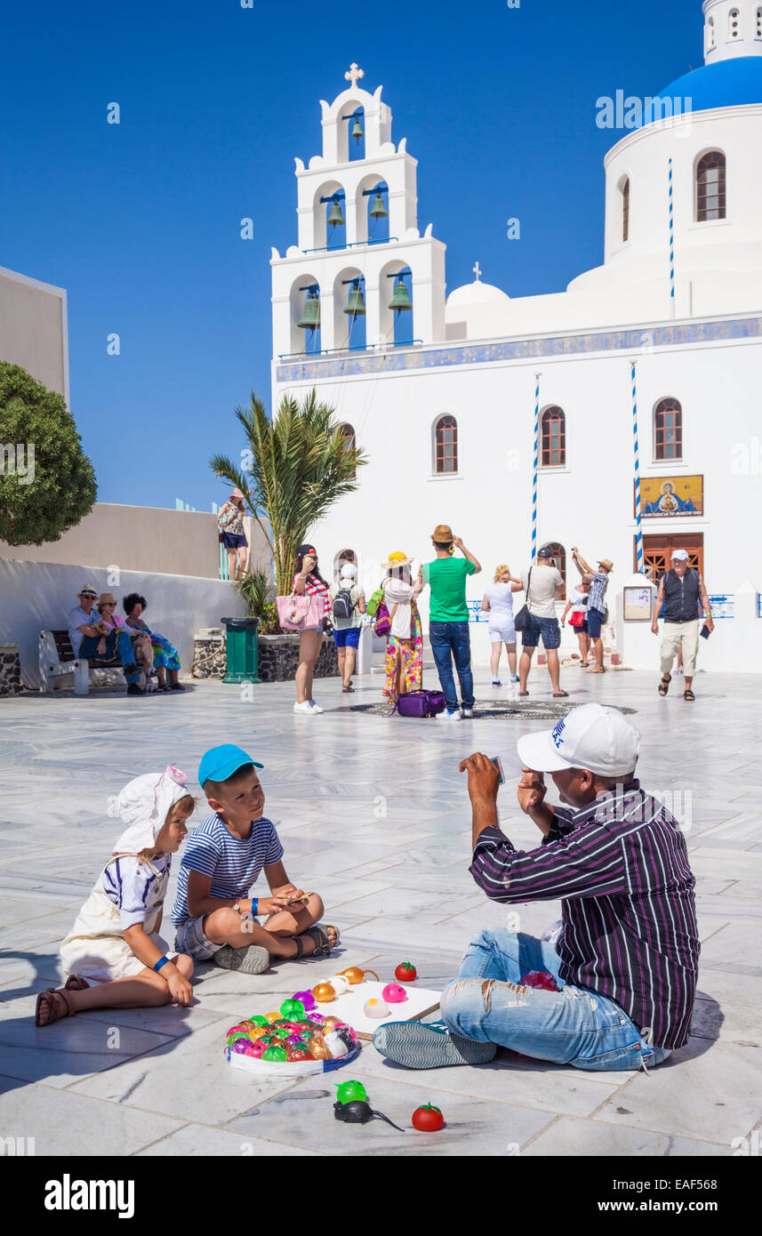 Vendeur de rue et les enfants à l'extérieur église Panagia Platsani Oia Santorin (thira) Îles Cyclades Iles grecques Grèce Europe Banque D'Images