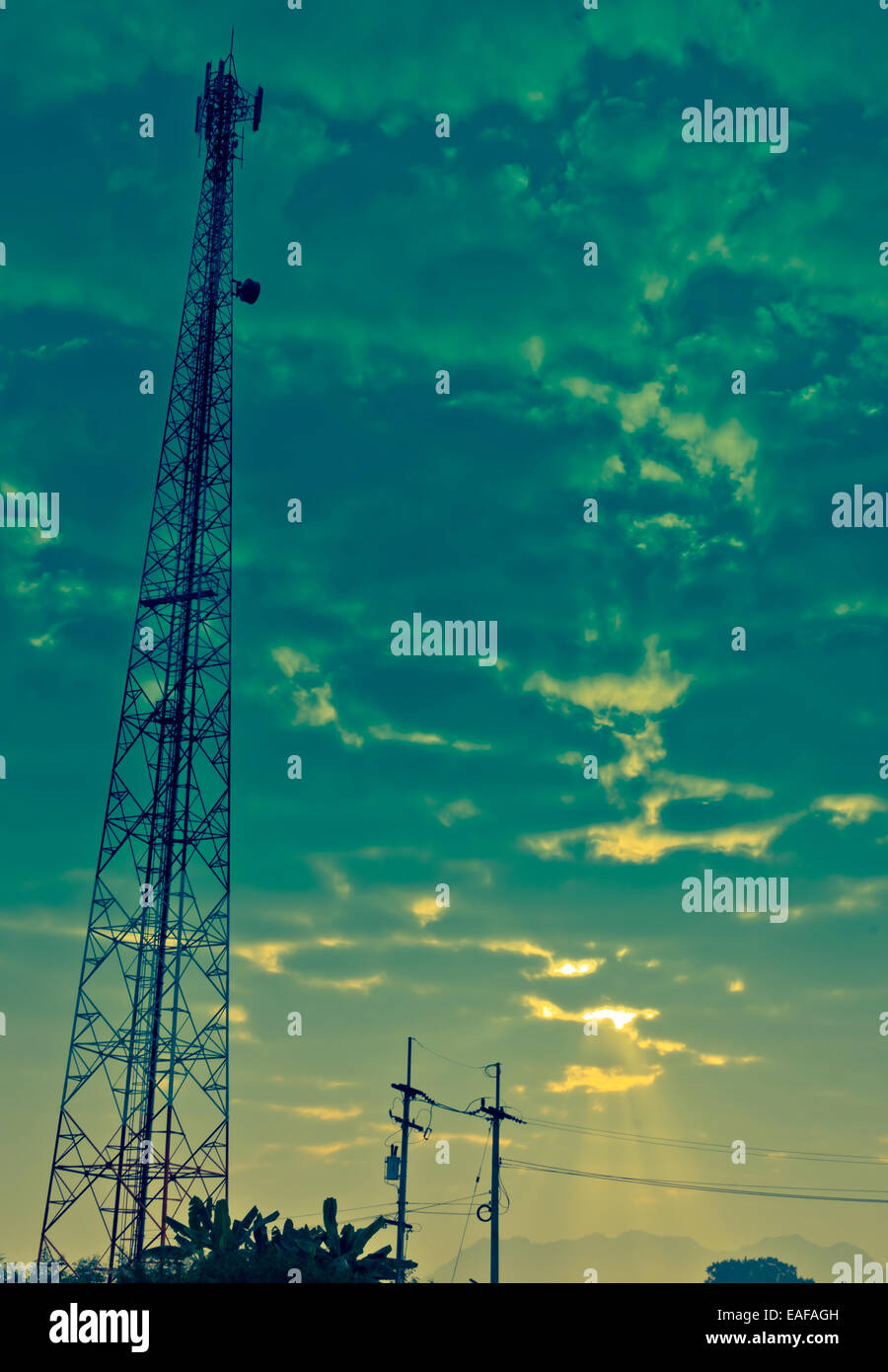 La tour de l'antenne de communication et ciel nuageux avec rayon de soleil le matin. Banque D'Images