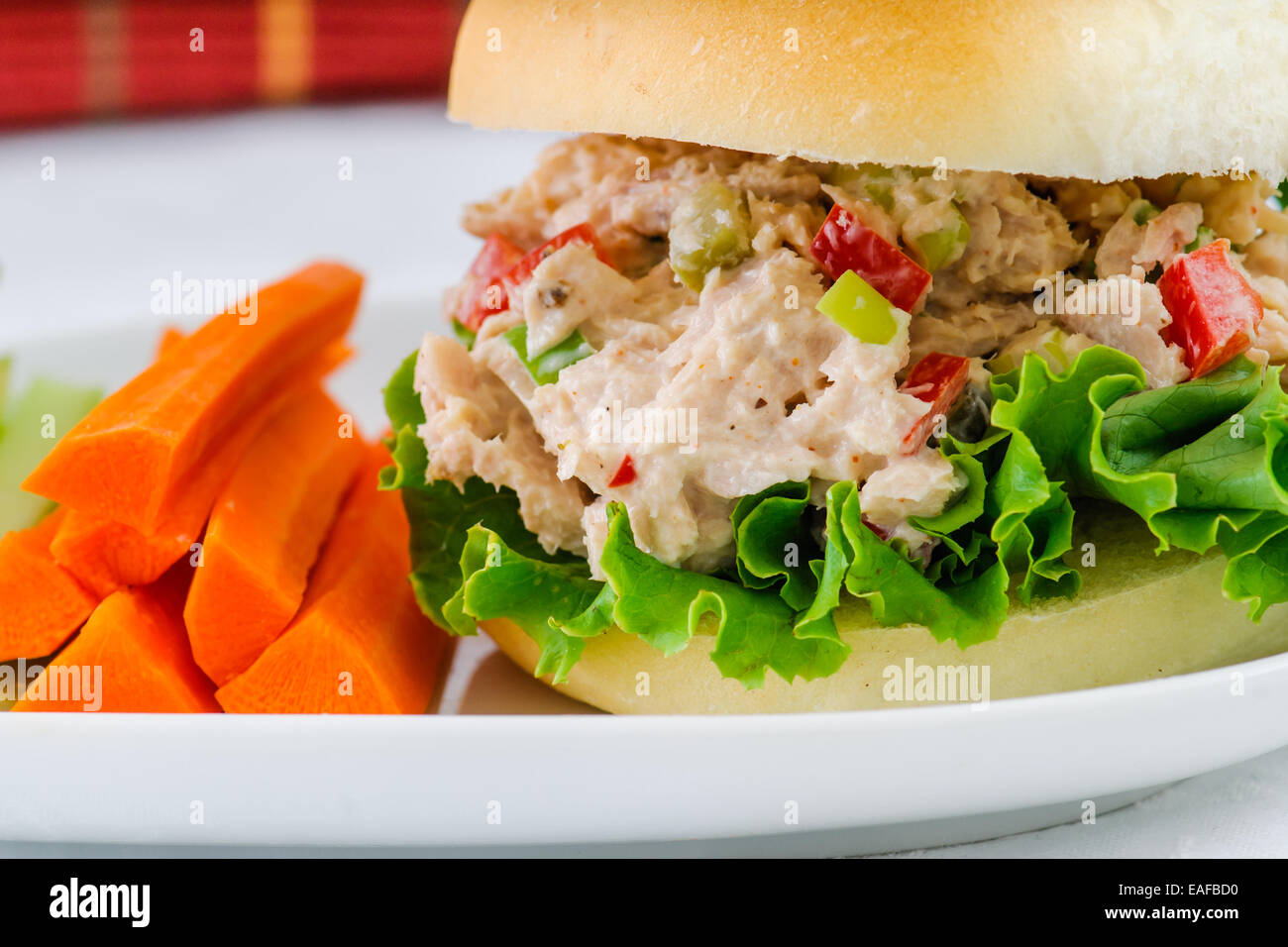 Sandwich à la salade de thon avec de la laitue sur une maison saine pain avec des bâtonnets de carotte et de céleri et un cornichon Banque D'Images