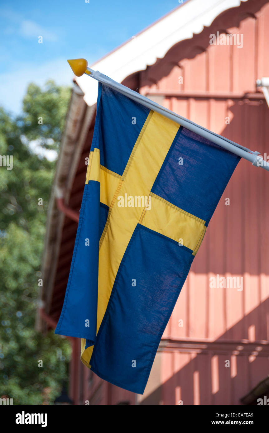 La Suède waving flag sur un red cottage Banque D'Images