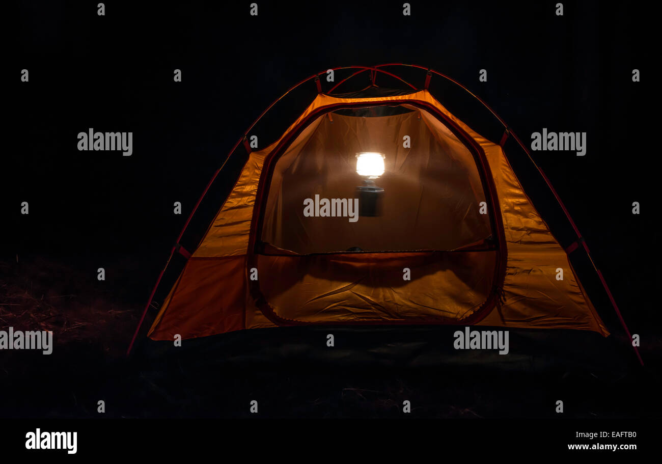 Orange tente dans la forêt la nuit Banque D'Images