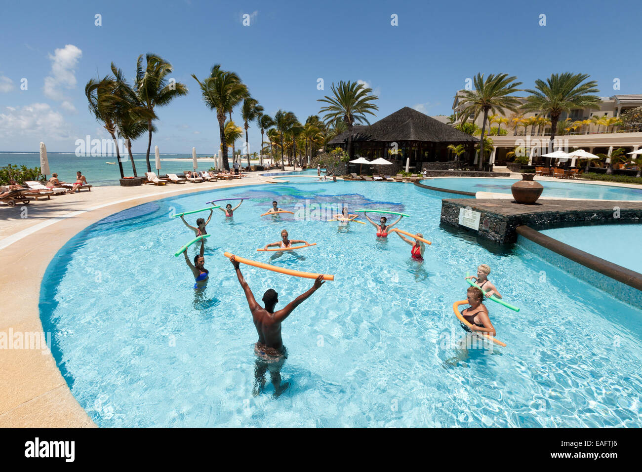 Les femmes qui font une classe d'aérobic de l'eau à l'extérieur dans la piscine de l'hôtel, Hotel, Ile Maurice Banque D'Images