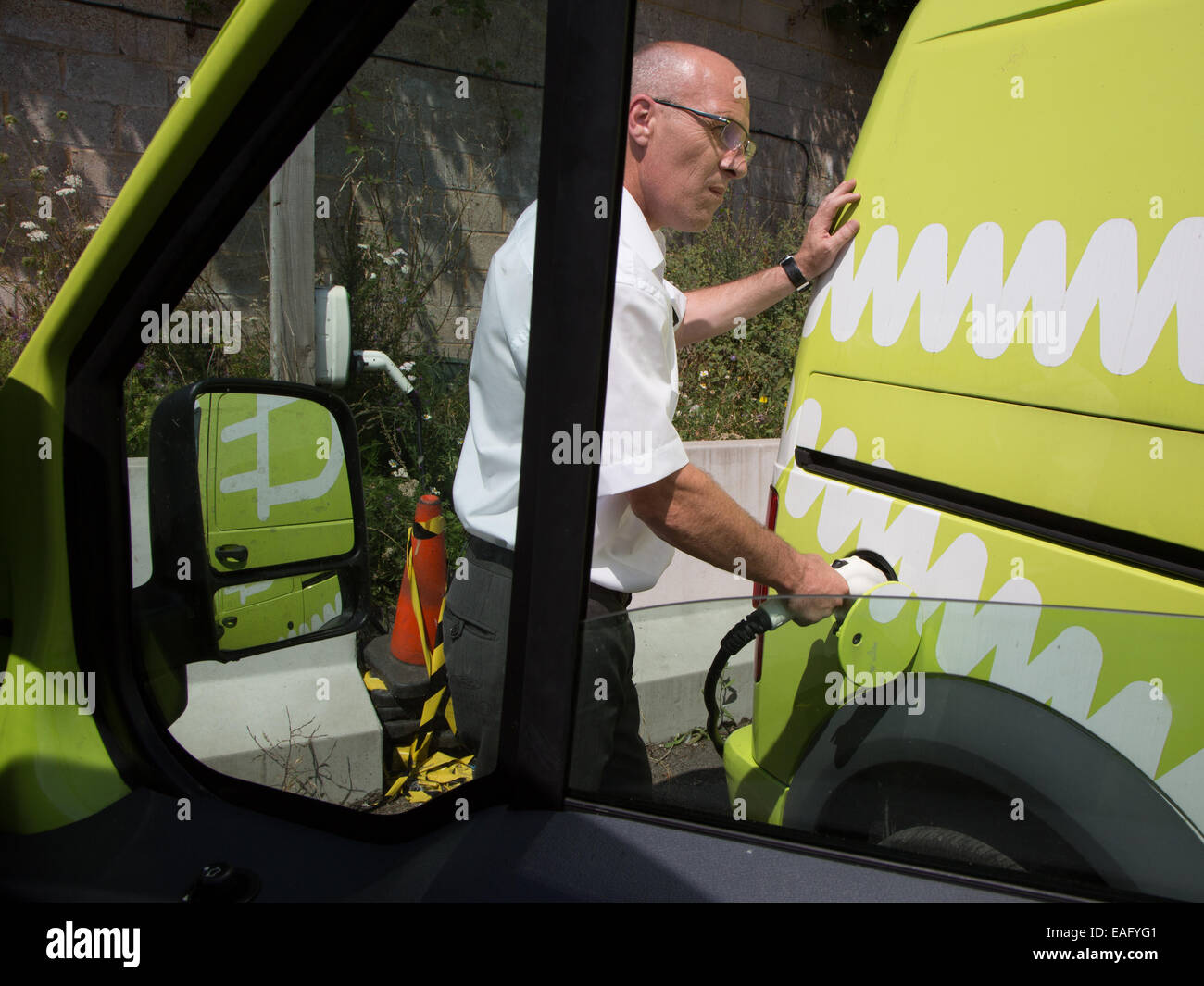 L'homme demande un fourgon électrique à un conseil de Brighton depot. Banque D'Images