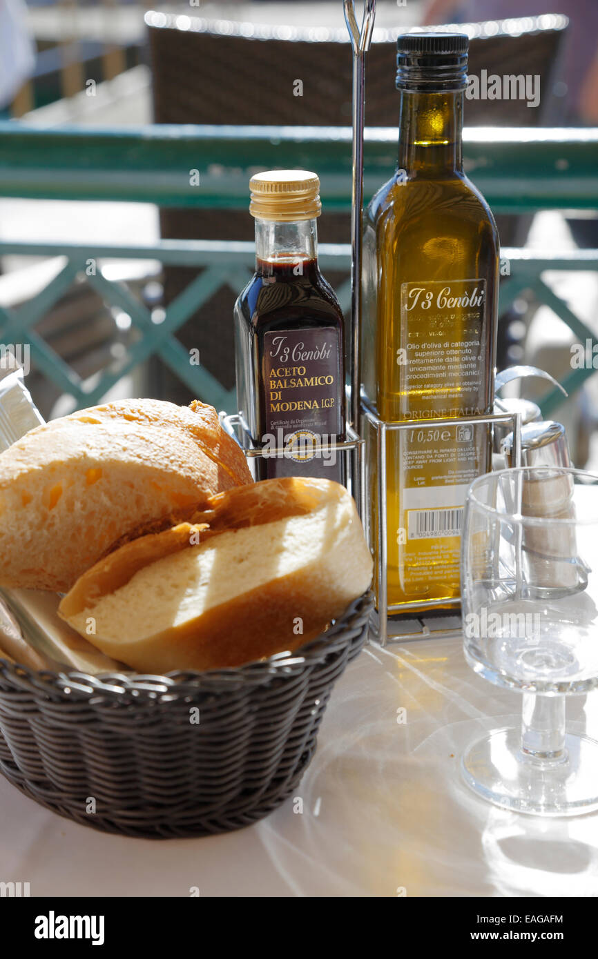 L'huile d'olive, vinaigre balsamique et une corbeille de pain ciabatta sur une table de restaurant à Venise, Italie. Pain de focus. Banque D'Images