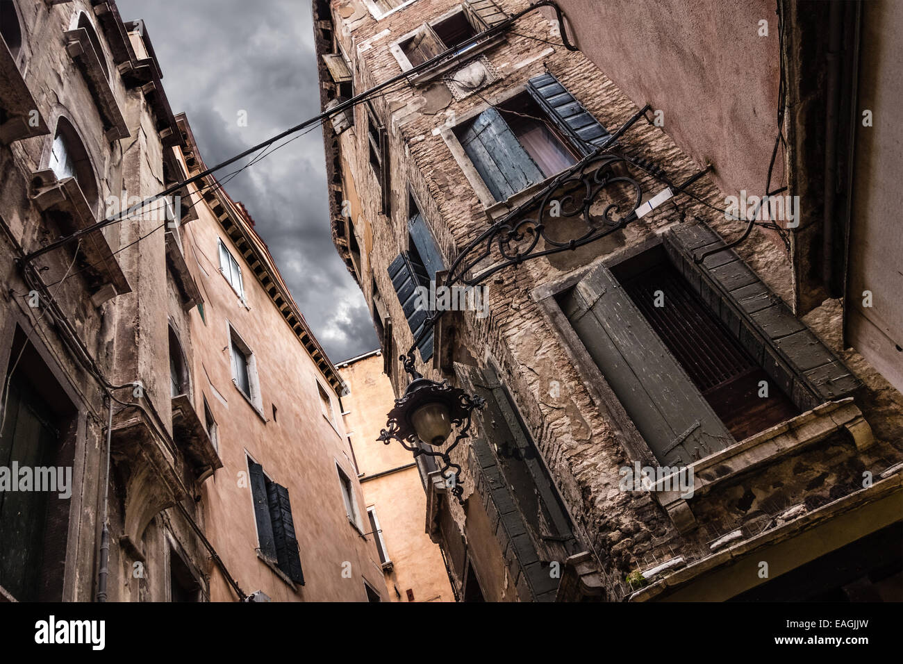 Point de vue d'une ruelle sombre avec ciel sombre à Venise, Italie Banque D'Images